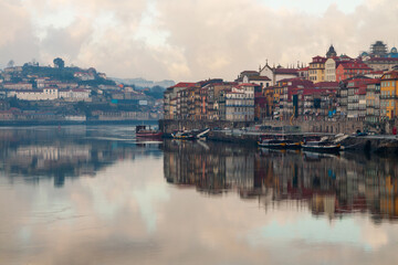 Fototapeta na wymiar Porto, Portugal panoramic cityscape on the Douro River at sunset. Urban landscape at sunset with traditional boats of Oporto city. Downtown and historic center, travel destination. Oporto landmark.