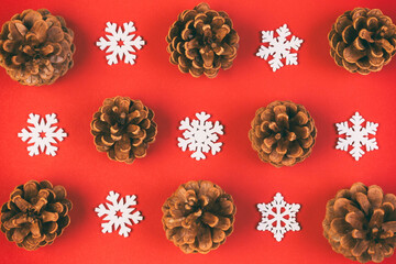 Top view of holiday composition made of pine cones and white snowflakes on colorful background. Winter time and Christmas concept with copy space