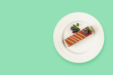 piece of chocolate cake with berries in a plate on a table. Top view