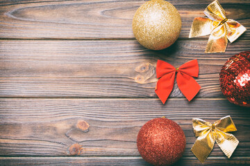 Top view of Christmas balls and creative decorations on wooden background with copy space. New Year...