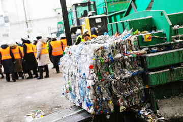 Briquettes of plastic garbage on the background of the workers of the waste recycling plant....