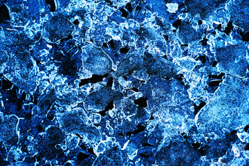 Flat background of ice layers on black. Beautiful background in blue shades with elements of air bubbles