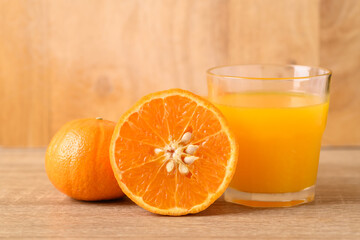 Fresh Honey Murcott orange fruit and juice on wooden background
