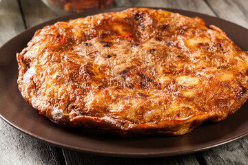 Tortilla de patatas. Spanish omelette with sausage chorizo, potatoes, paprika and egg, accompanied by olive oil