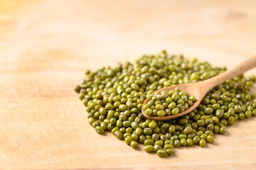 Pile mung bean with spoon on wooden background