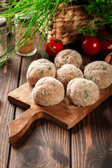 Raw meatballs rolled in a crispy bun prepared for baking