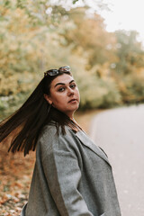 Beautiful woman in a gray coat on an autumn alley