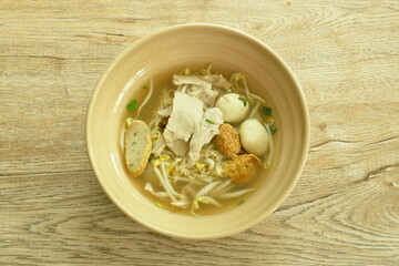 Chinese egg yellow noodles topping slice boiled pork and ball with soup in bowl