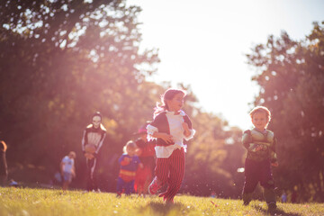 Kids in Halloween suits running trough nature.