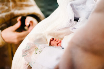 The sacrament of baptism. Newborn baby during christening and chrismation. Infant baby baptism in Holy water.