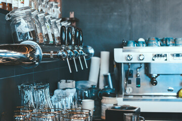 Wall in the interior of the bar. Coffee machine, mugs, glasses, bottles of alcohol.
