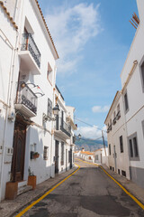 Fototapeta na wymiar Beautiful empty narrow street in Altea, Costa Blanca, Valencian Community, Spain. Historical center. Vertical shot. White greek-like architecture. 