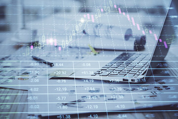 Stock market graph on background with desk and personal computer. Multi exposure. Concept of financial analysis.