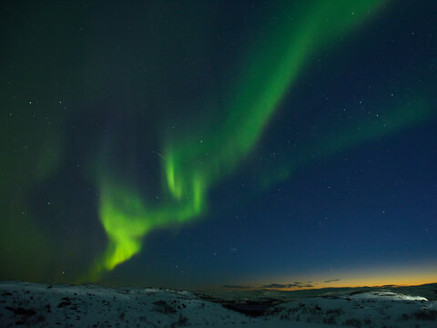 Night sky. Northern lights stars hills snow in winter, stones. © Moroshka