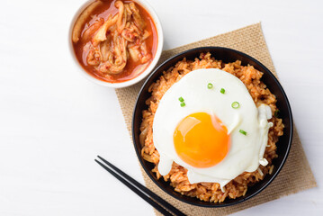Korean food, Kimchi fried rice with fried egg in a bowl and chopsticks ready to eating, Top view