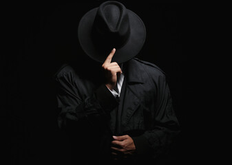Old fashioned detective in hat on dark background