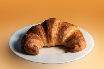 croissant on dessert plate on orange background