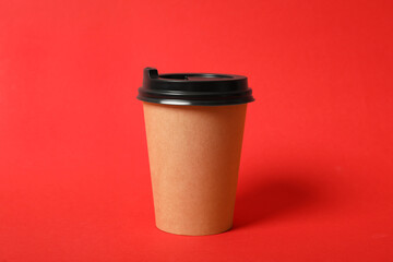 Takeaway paper coffee cup on red background