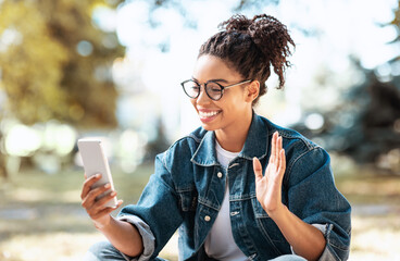 African American Woman Using Smartphone Making Video Call Sitting Outside