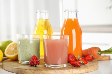Different juices and fresh fruits on wooden board