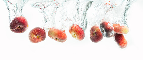 Bunch of doughnut peaches isolated on white background, splashing into water.