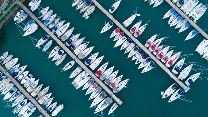 Fotobehang Aerial top view of a lot of white boats and sailboats moored in marina on a turquoise water, summer season. Yacht week, hundreds of yachts in port. Monaco, France, Croatia, Italy, Fort Lauderdale. © SARATSTOCK