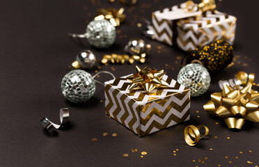 Christmas composition. Gold and silver decorations, mirror disco balls, gifts on  dark black background.