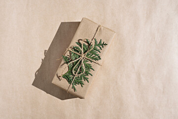 gift craft box with branch of thuja on craft background, new year's composition