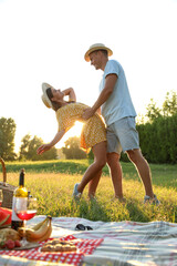 Happy couple dancing on picnic in park