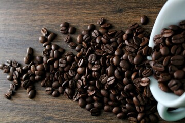 coffee beans falling from a coffee cup (mug)