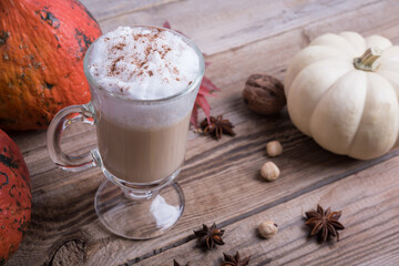 latte with whipped cream on wooden table, autumn background