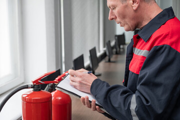 Engineer Professional are Checking A Fire Extinguisher Using Clipboard or checking Industrial fire control system,Fire Alarm controller, Fire notifier, Anti fire.System ready In the event of a fire.