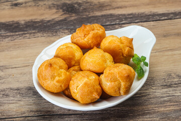 Sweet tasty profiteroles heap in the bowl