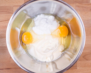 Sour cream, mayonnaise, raw eggs in a bowl. Ingredients for making pie dough