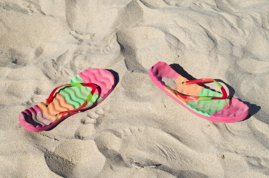Colorful flip flops in the sand on the beach