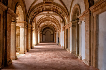Fototapeta na wymiar Side-lit Cloister Hallway With Columns And Ribbed Vaulted Ceilings. Templar Castle/Convent Of Christ, Tomar, Portugal.