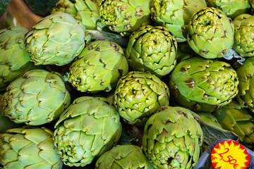 Obraz premium Fresh whole artichokes for sale on display of farmer market ..