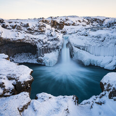 Aldeyjarfoss waterfall at sunset in winter. Columnar basalt formations around the fall. North Iceland.