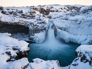 Aldeyjarfoss waterfall at sunset in winter. Columnar basalt formations around the fall. North Iceland.