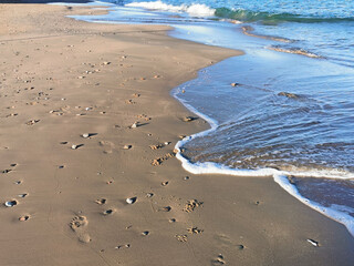 Empty beach, waves and blue sky at the mediterranean sea shore line