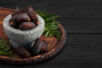 Bowl of dried dates on dark wooden background
