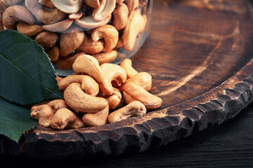 Bowl with cashew nuts on wooden table. Delicacies