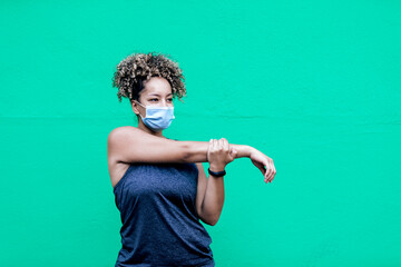 curly-haired woman and sportswear on a green wall