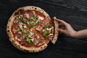 Close up on delicious freshly baked small pizza with melted cheese mushrooms and basil