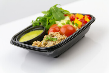 Salad with tuna, tomatoes, pepper, rocket, cucumber, sauce, white background