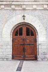 Old stone house wall with dark wooden door