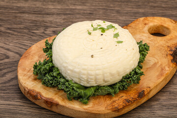 Caucasian suluguni round cheese piece