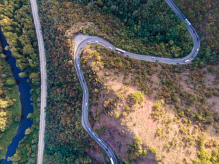 Top down aerial drone view of road with traffic in the mountain