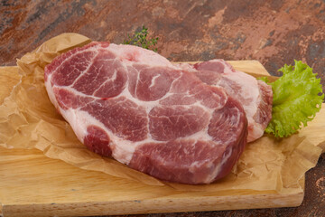 Raw pork steak over wooden board