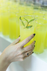 woman's hand holding glass of lemonade